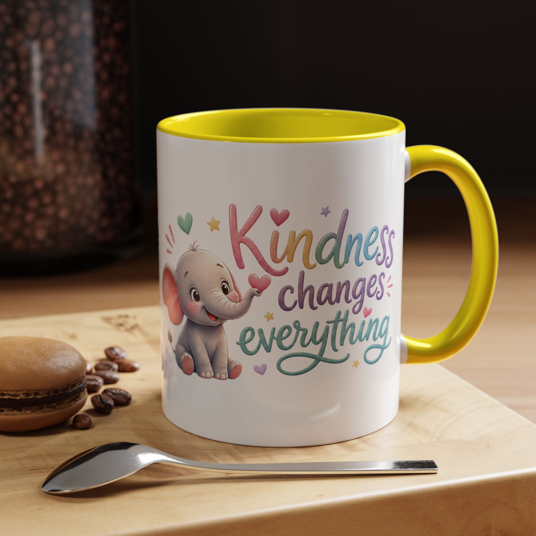 Cute ceramic coffee mug featuring a pastel baby elephant and the uplifting message “Kindness Changes Everything” with colorful accent handle and interior.