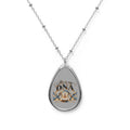 Silver-tone elliptical Christian pendant necklace featuring It's in My DNA gold-and-blue artwork with intertwined DNA strands, praying hands, decorative wings, and an open Bible on a gray background.