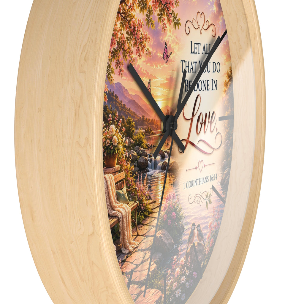 Inspirational Christian wall clock featuring a flower-lined lakeside sunrise scene with 1 Corinthians 16:14 scripture about doing all things in love.