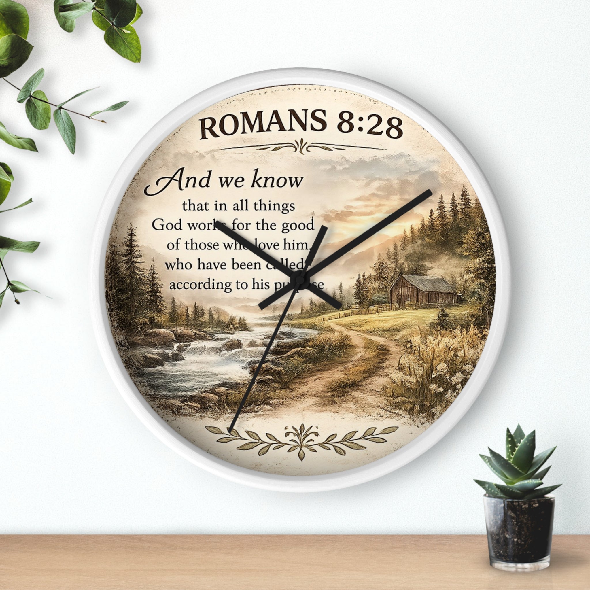 Inspirational Christian wall clock featuring Romans 8:28 scripture with a rustic cabin, flowing creek, and sunset landscape in warm countryside colors.