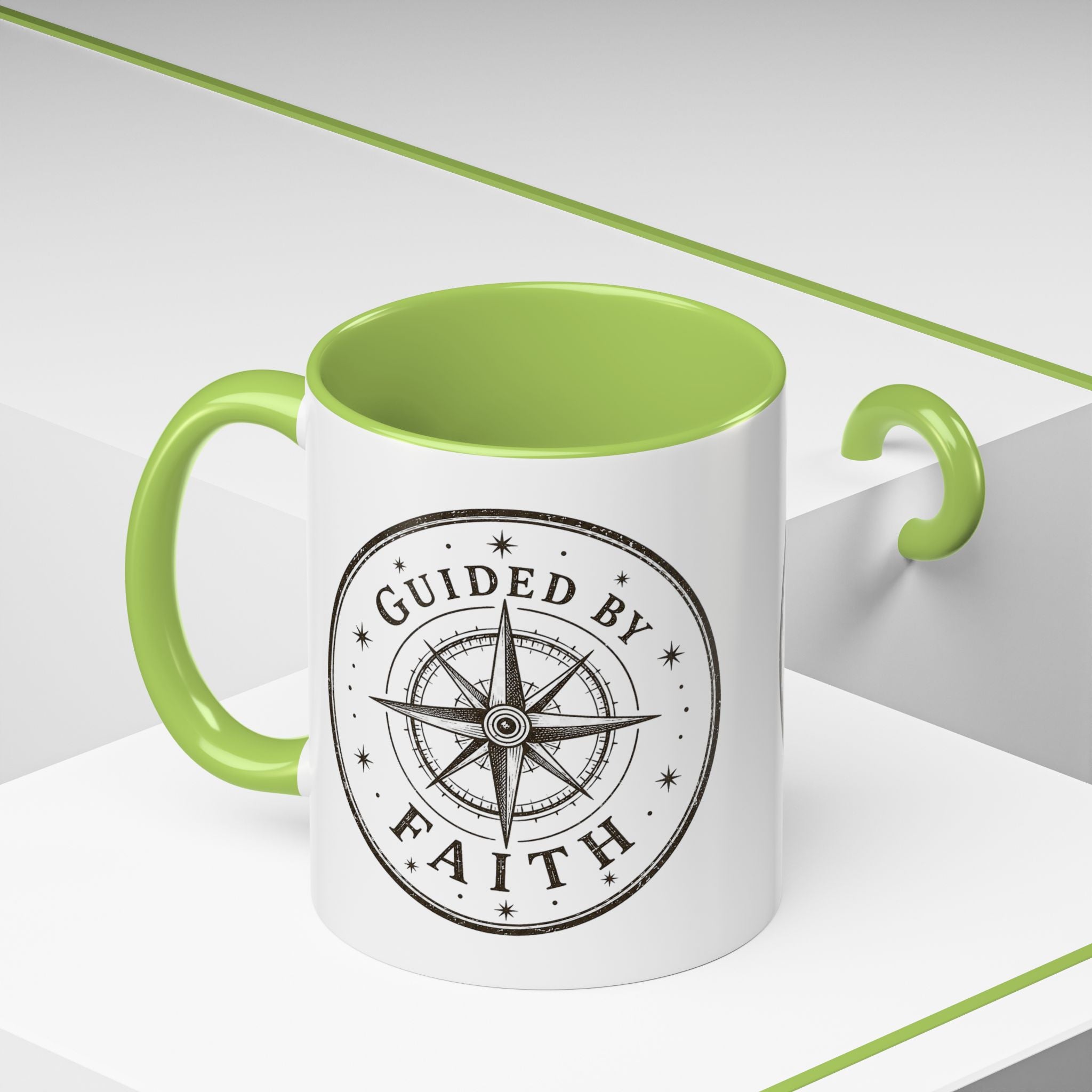 Inspirational ceramic accent coffee mug featuring a compass design and “Guided by Faith” message with colorful handle and interior accents on a glossy white mug.