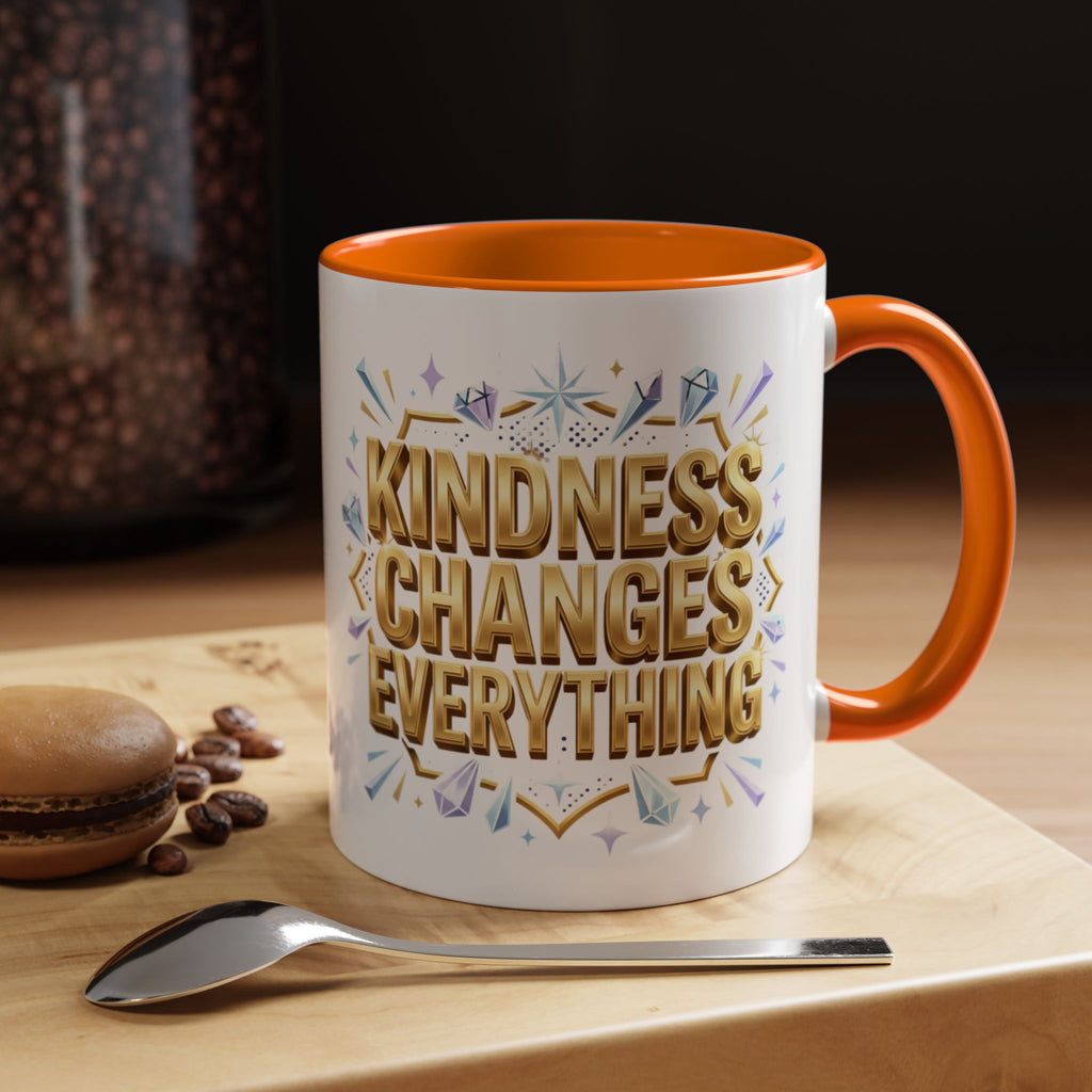 Inspirational ceramic accent coffee mug featuring “Kindness Changes Everything” in elegant gold script with sparkles and colorful accent handle and interior.