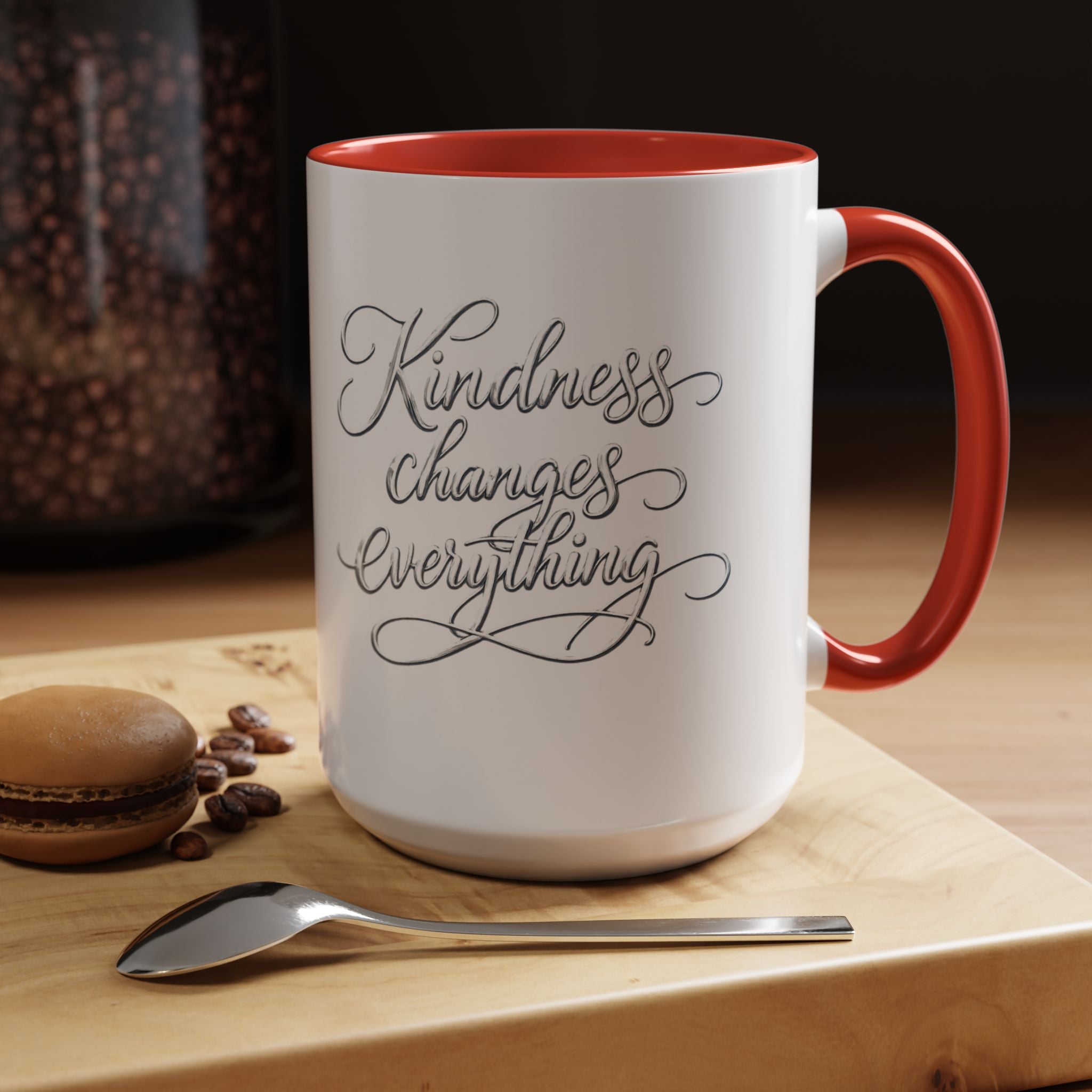 Inspirational ceramic accent coffee mug featuring elegant silver hand-lettered “Kindness Changes Everything” typography with colorful handle and interior accents.