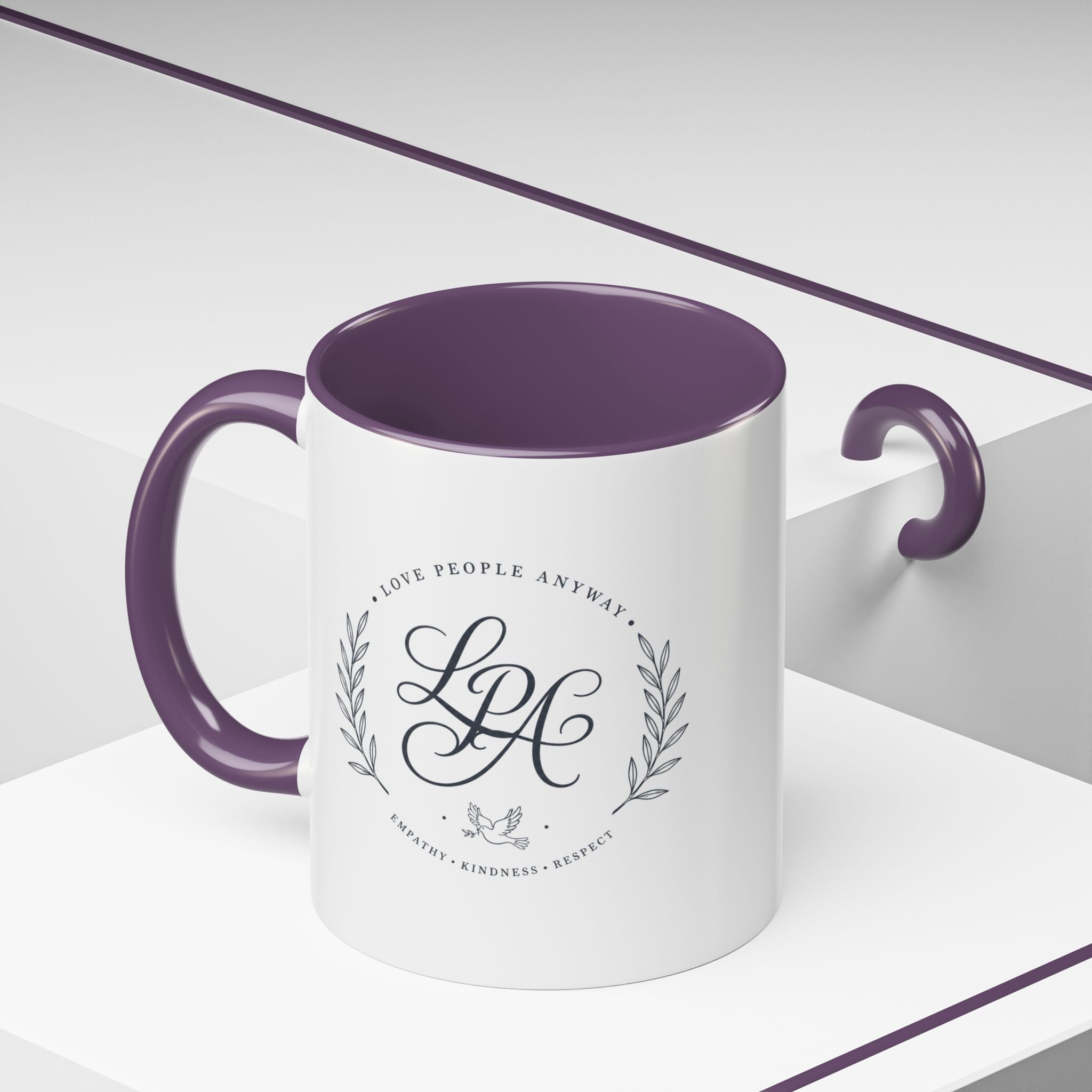 Personalized ceramic accent coffee mug featuring a custom monogram crest and the inspirational message “Love People Anyway” with colorful handle and interior accents.