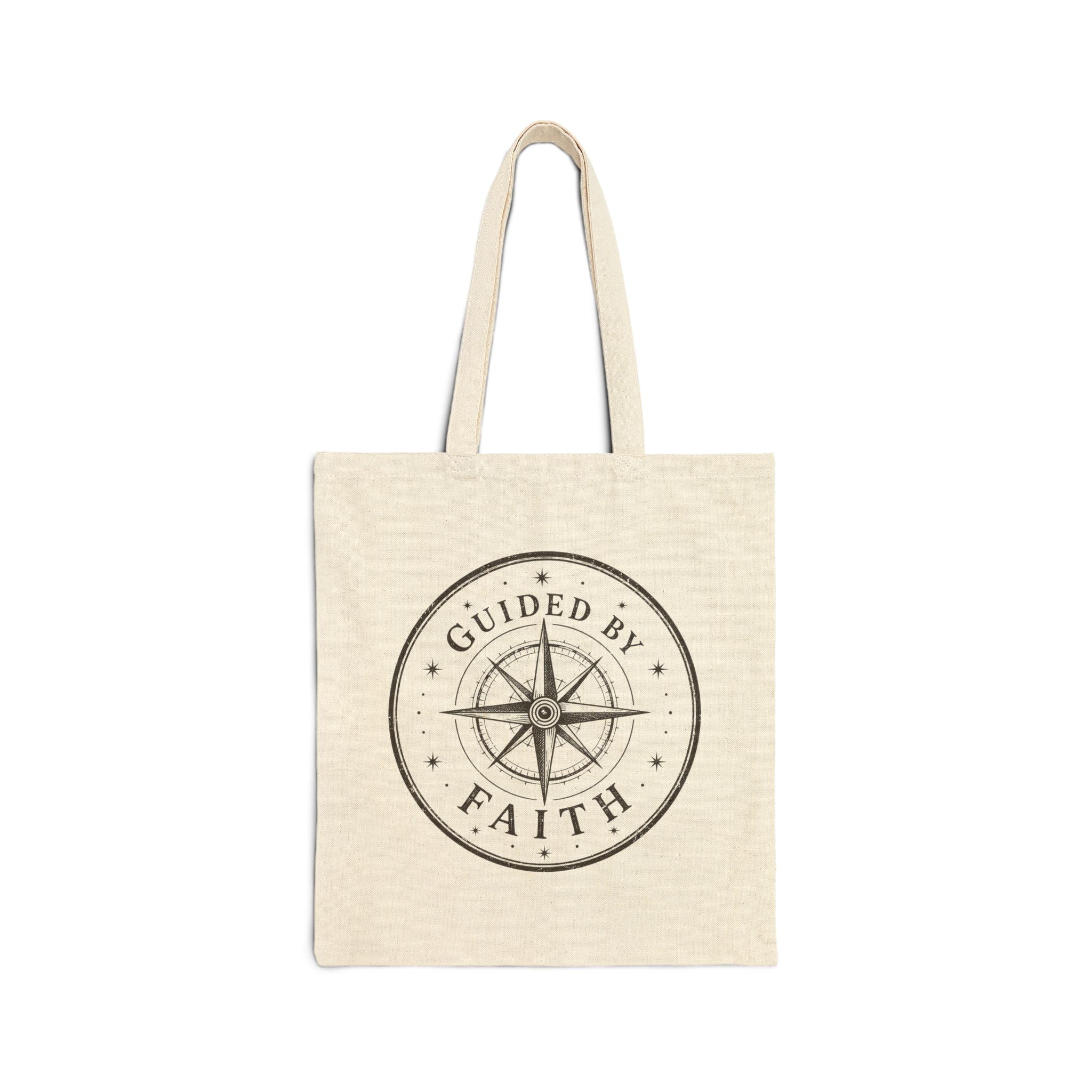 Rustic cotton canvas tote bag featuring a vintage compass rose surrounded by stars and the words "Guided by Faith" in a distressed black-and-cream design.