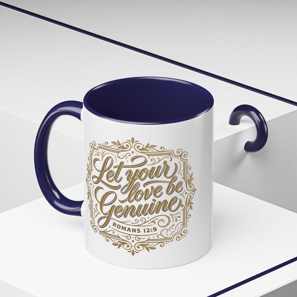 Inspirational ceramic accent coffee mug featuring Romans 12:9 and the message “Let Your Love Be Genuine” in elegant gold script with decorative flourishes and black accent handle and interior.