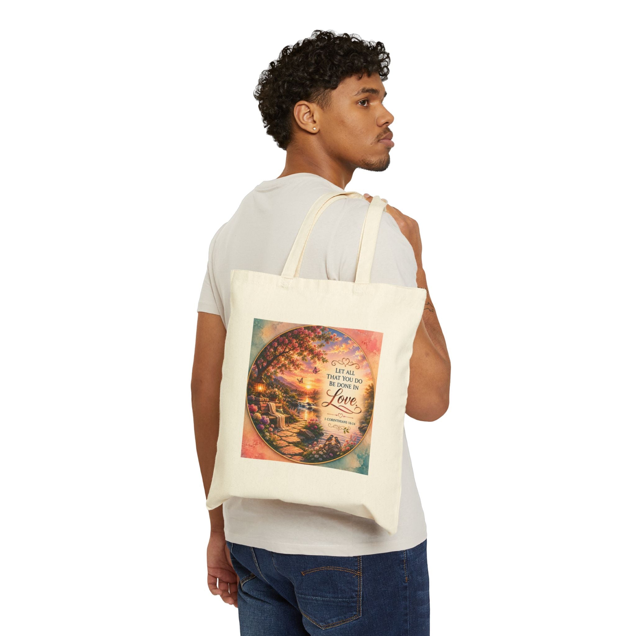 Christian cotton canvas tote bag featuring 1 Corinthians 16:14, “Let All That You Do Be Done in Love,” with a peaceful garden landscape, blooming flowers, butterflies, flowing river, lantern, birds, and sunset artwork.