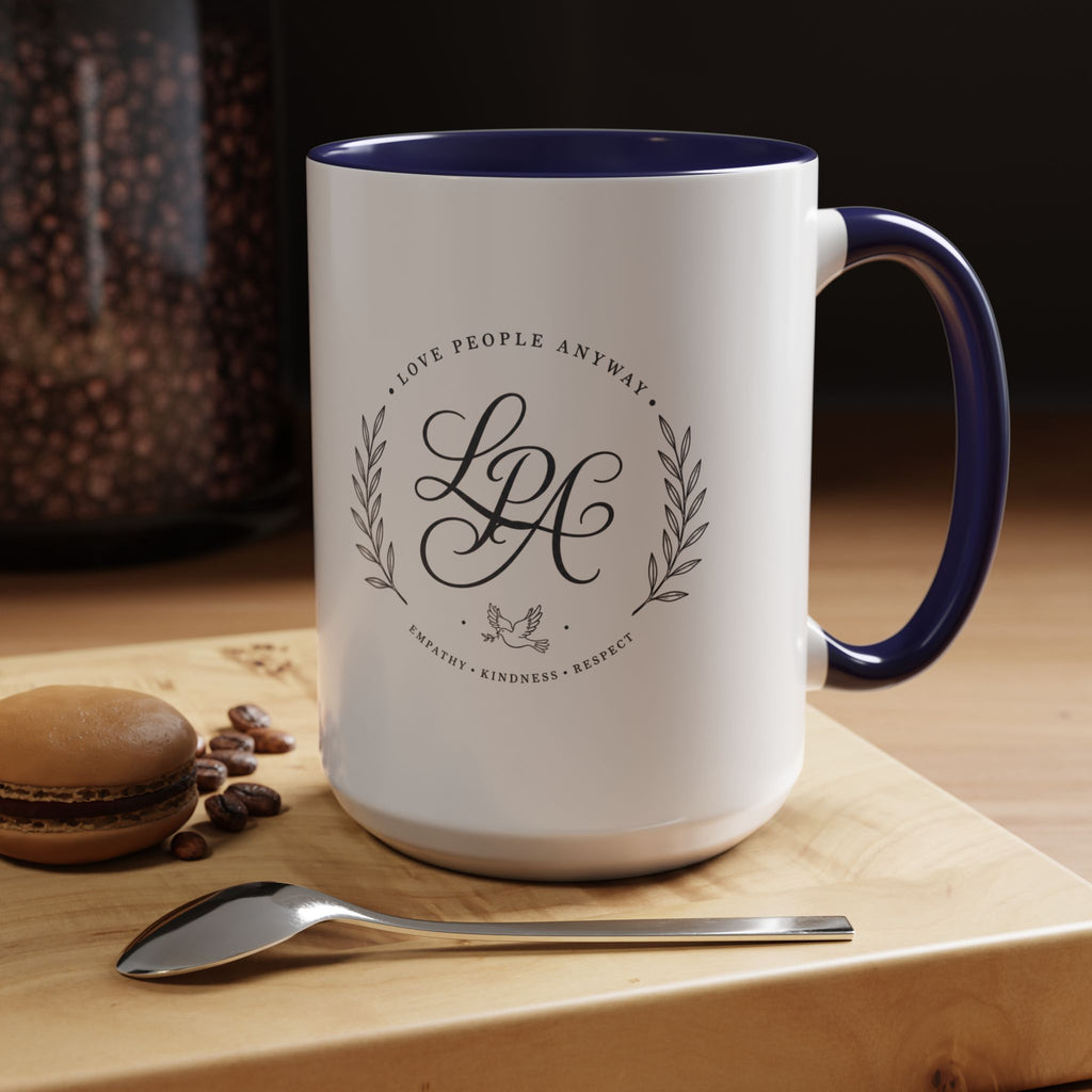 Personalized ceramic accent coffee mug featuring a custom monogram crest and the inspirational message “Love People Anyway” with colorful handle and interior accents.