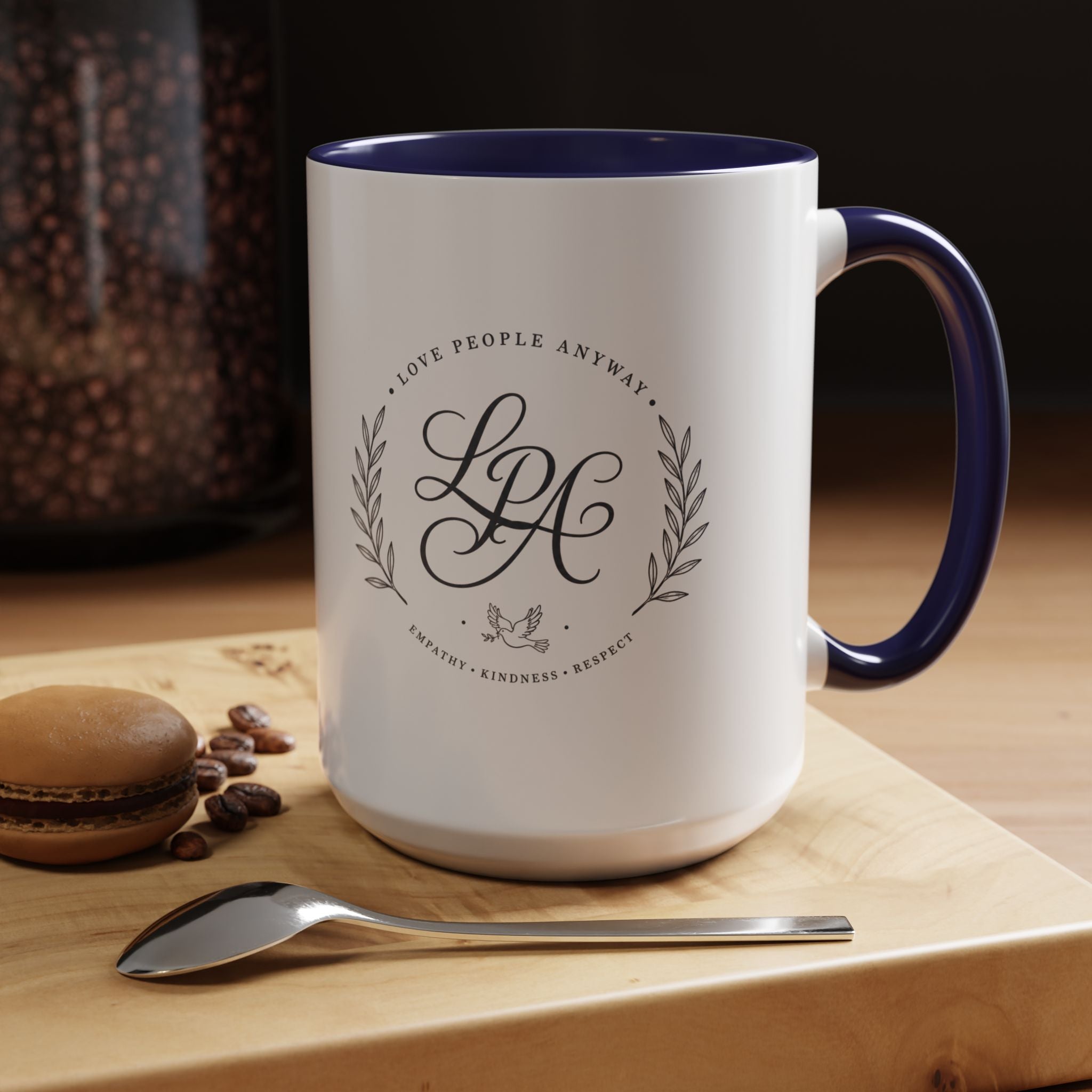 Personalized ceramic accent coffee mug featuring a custom monogram crest and the inspirational message “Love People Anyway” with colorful handle and interior accents.