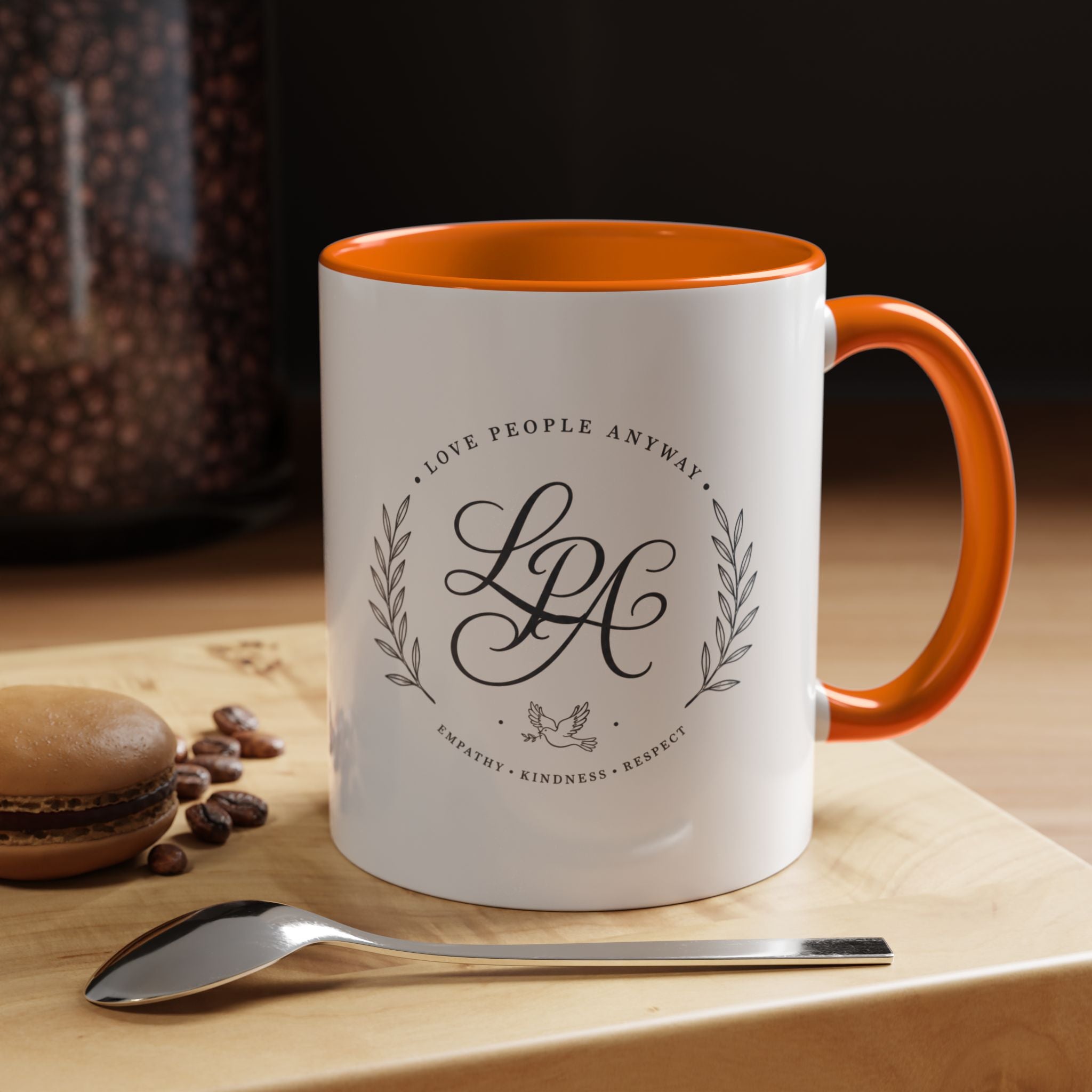 Personalized ceramic accent coffee mug featuring a custom monogram crest and the inspirational message “Love People Anyway” with colorful handle and interior accents.
