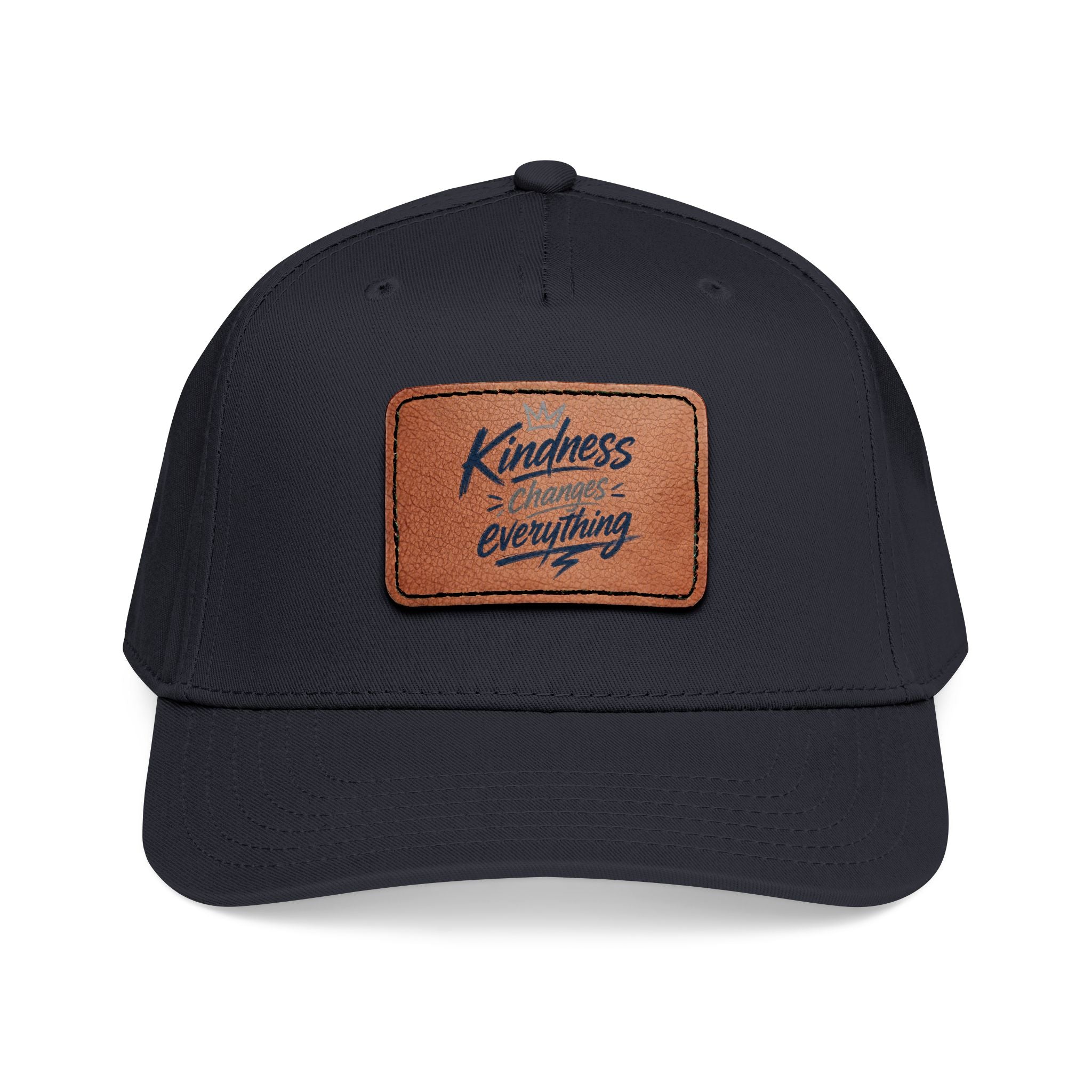 Vintage-inspired baseball cap featuring a brown leather patch with the phrase “Kindness Changes Everything” on a structured mid-profile snapback hat.