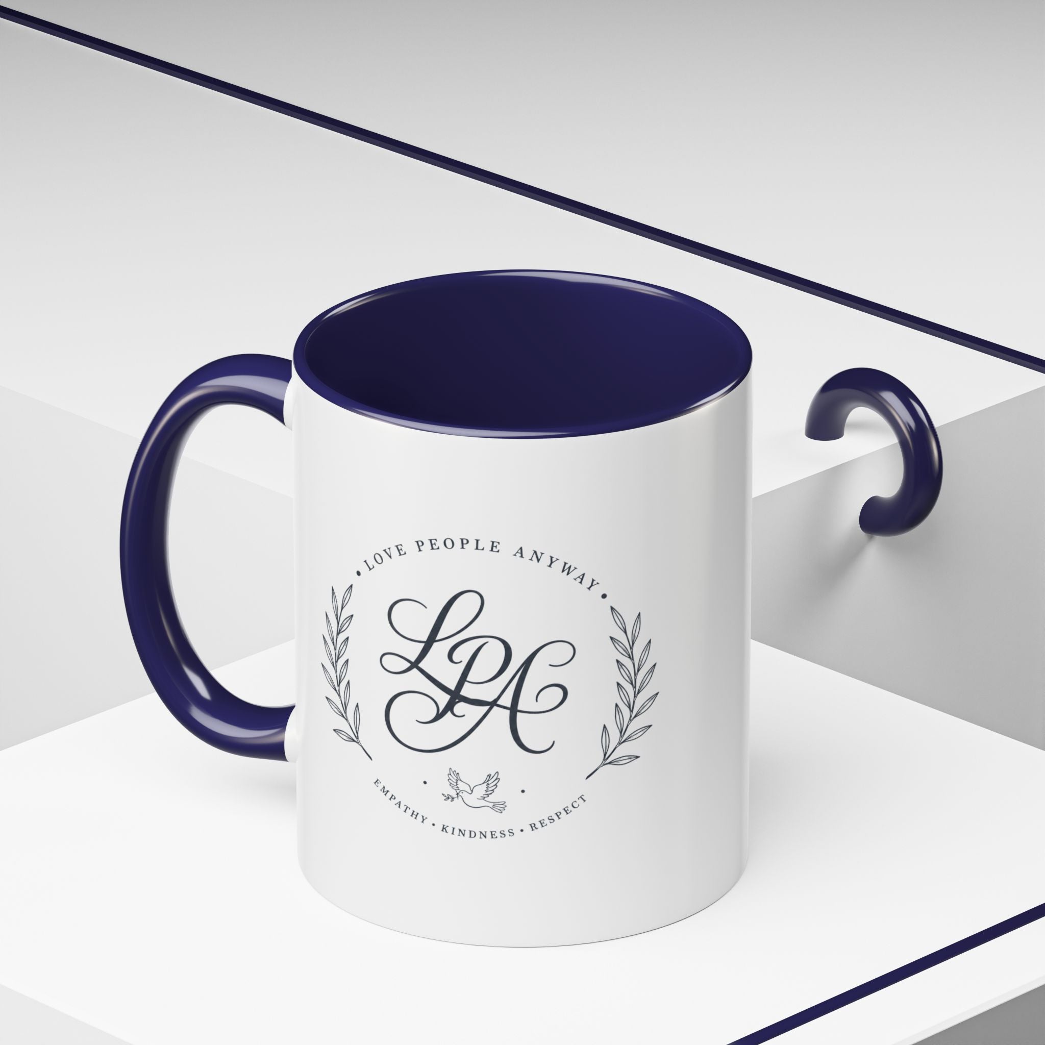 Personalized ceramic accent coffee mug featuring a custom monogram crest and the inspirational message “Love People Anyway” with colorful handle and interior accents.