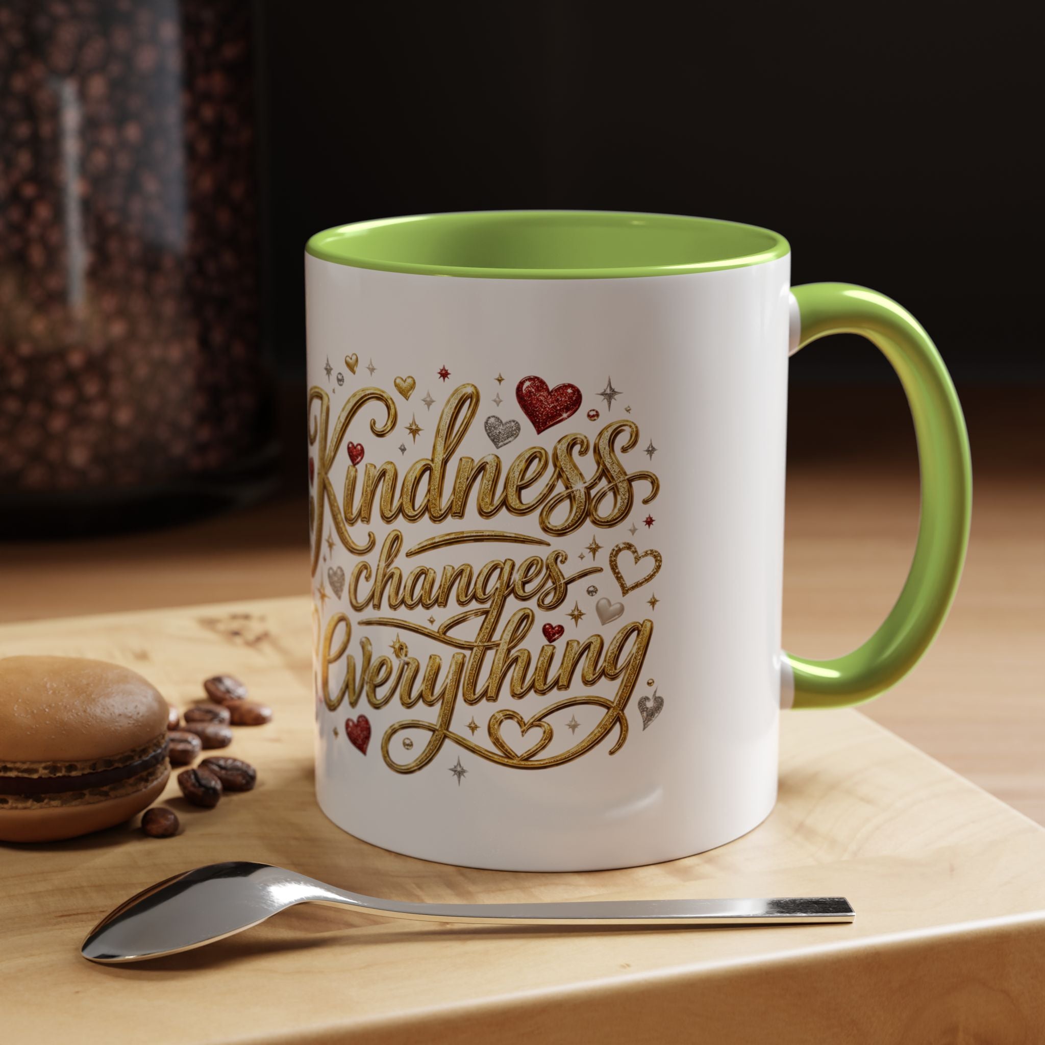 Inspirational ceramic coffee mug featuring the hand-lettered message “Kindness Changes Everything” with gold flourishes, hearts, and colorful accent handle and interior.