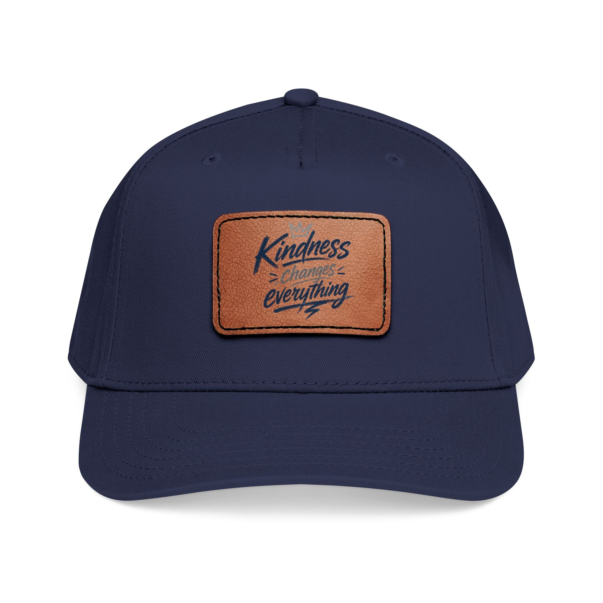 Vintage-inspired baseball cap featuring a brown leather patch with the phrase “Kindness Changes Everything” on a structured mid-profile snapback hat.